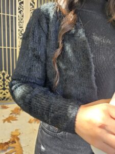 مدل زن با کت موهر مشکی کراپشده، شلوار جین مشکی و کلاه سفید، مناسب استایل پاییزه و زمستانه. طراحی شیک و گرم با جلوهای مدرن و نیمهرسمی.