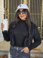 مدل زن با کت موهر مشکی کراپشده، شلوار جین مشکی و کلاه سفید، مناسب استایل پاییزه و زمستانه. طراحی شیک و گرم با جلوهای مدرن و نیمهرسمی.