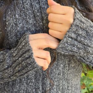 مدل با پلیور بافت ساده و ریز به رنگ خاکستری تیره، مناسب سایزهای 36 تا 42، در یک فضای پاییزی و زیبا.