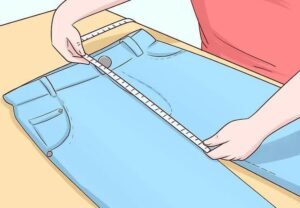 اندازهگیری شلوار جین روی سطح صاف برای انتخاب سایز مناسب شلوار.